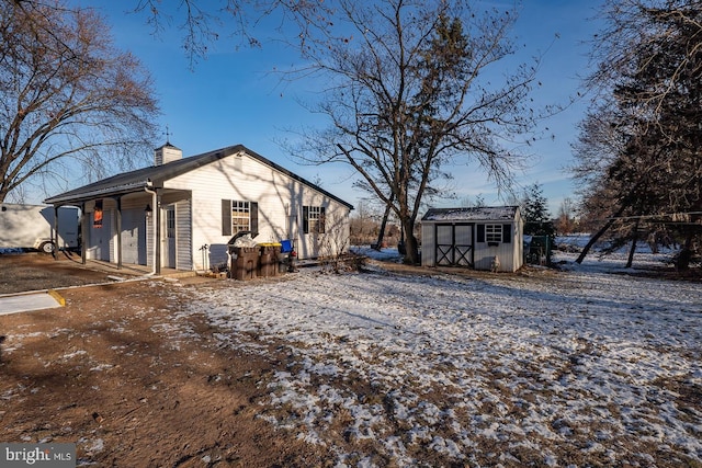 snow covered property with a shed