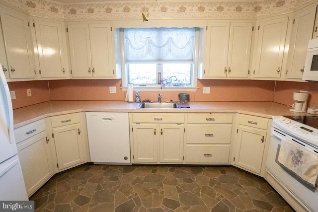 kitchen with white cabinetry, sink, and white appliances