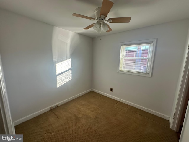 empty room featuring ceiling fan and carpet