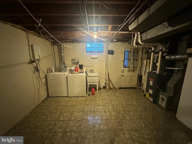 basement with sink, heating unit, and independent washer and dryer