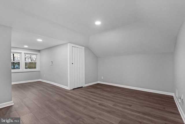 bonus room with dark wood-type flooring and lofted ceiling