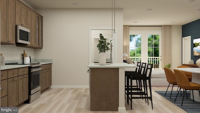 kitchen with hanging light fixtures, range, kitchen peninsula, a breakfast bar area, and light wood-type flooring