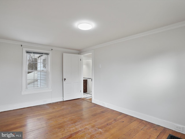 spare room with light hardwood / wood-style floors and crown molding