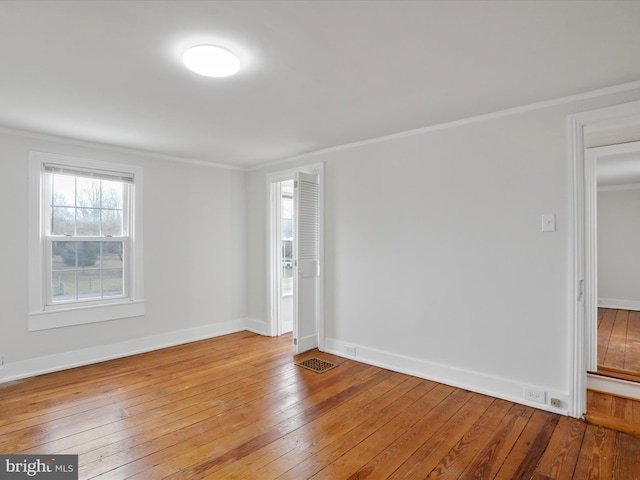 empty room with light hardwood / wood-style floors and ornamental molding