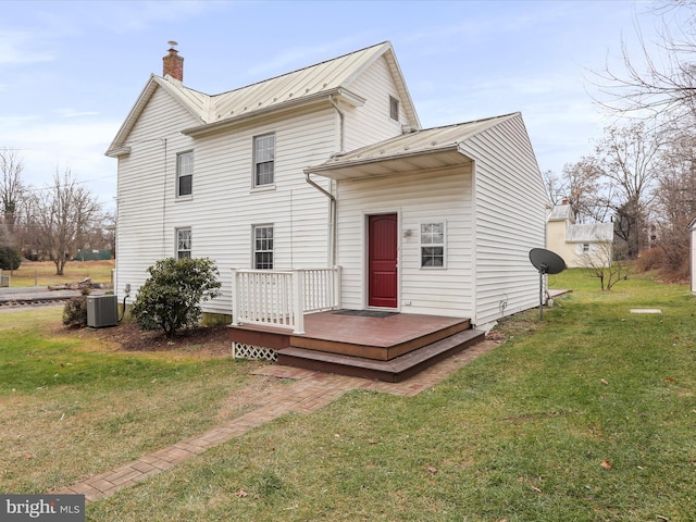 rear view of property with cooling unit, a yard, and a wooden deck