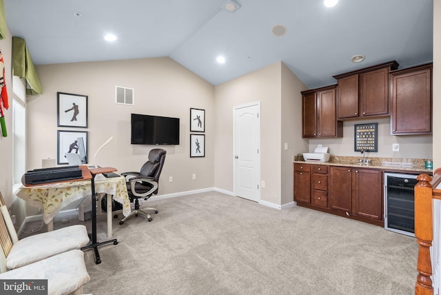 carpeted home office featuring wine cooler, sink, and vaulted ceiling