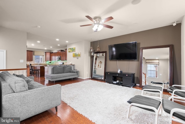 living room with dark hardwood / wood-style floors and ceiling fan