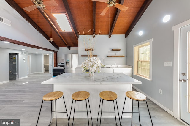 kitchen with vaulted ceiling with beams, stainless steel fridge with ice dispenser, wood ceiling, and light wood-type flooring