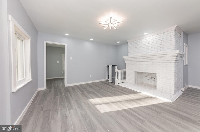 unfurnished living room with a fireplace and light hardwood / wood-style flooring