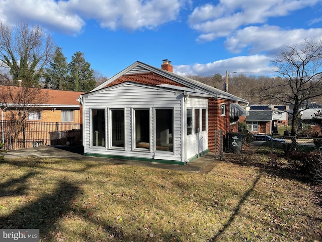 rear view of house featuring a yard