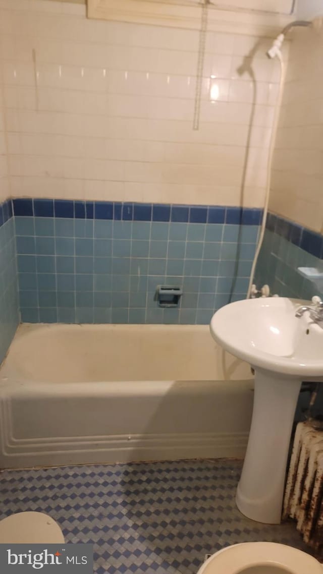 bathroom featuring shower / washtub combination and toilet