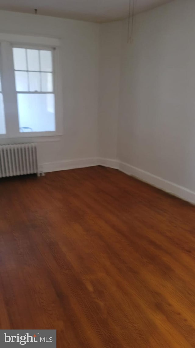 unfurnished room featuring radiator and wood-type flooring