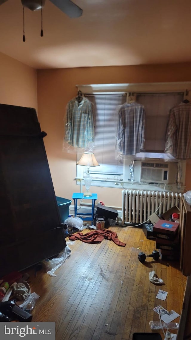 bedroom featuring hardwood / wood-style flooring and radiator