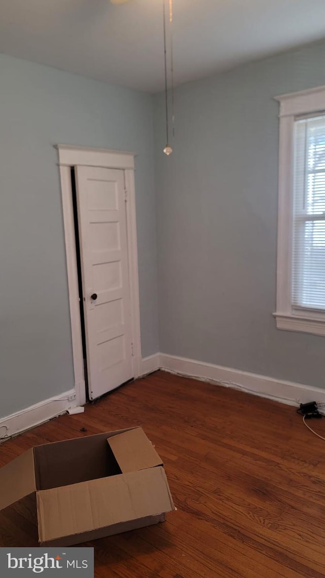 unfurnished room with dark wood-type flooring