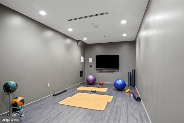 exercise room with visible vents, recessed lighting, baseboards, and wood finished floors