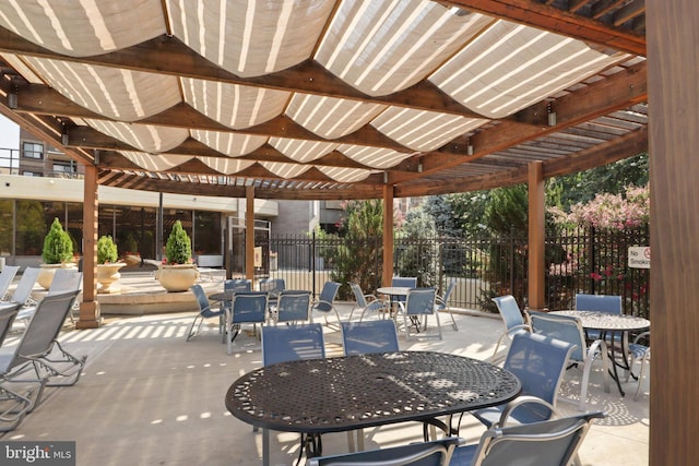 view of patio with outdoor dining space, fence, and a pergola