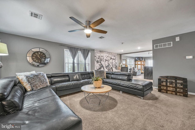 carpeted living room with ceiling fan