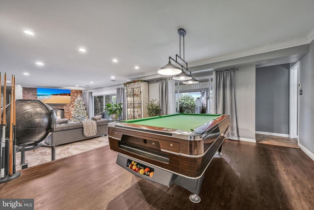 playroom featuring hardwood / wood-style floors, ornamental molding, a fireplace, and pool table