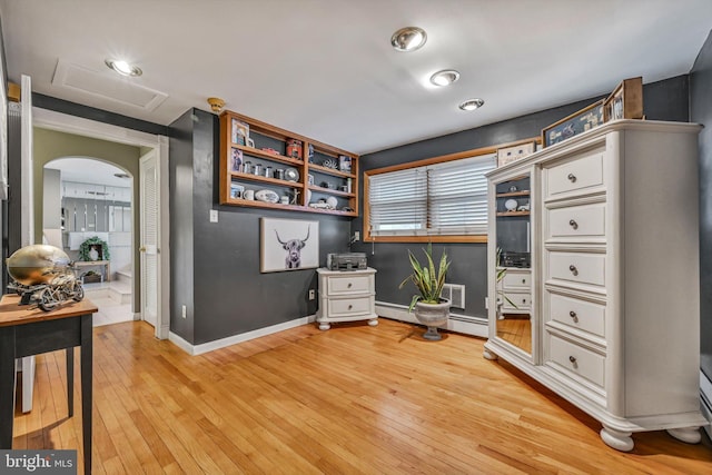 office with light hardwood / wood-style floors and a baseboard radiator