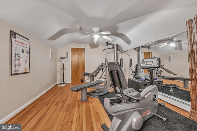 exercise room with baseboard heating, ceiling fan, vaulted ceiling, and light wood-type flooring