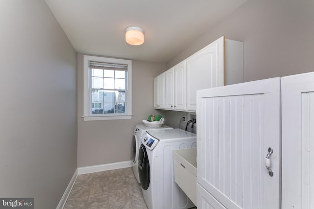 laundry room featuring washer and dryer and cabinets