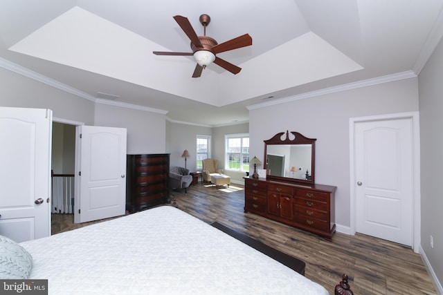 bedroom featuring ceiling fan, dark hardwood / wood-style floors, ornamental molding, and a tray ceiling