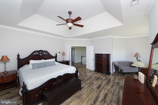 bedroom with dark hardwood / wood-style floors, a raised ceiling, ceiling fan, and crown molding