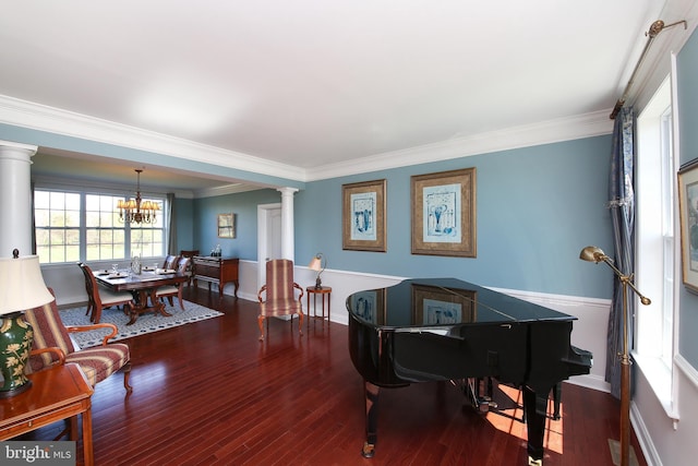 interior space featuring a notable chandelier, ornamental molding, dark wood-type flooring, and decorative columns