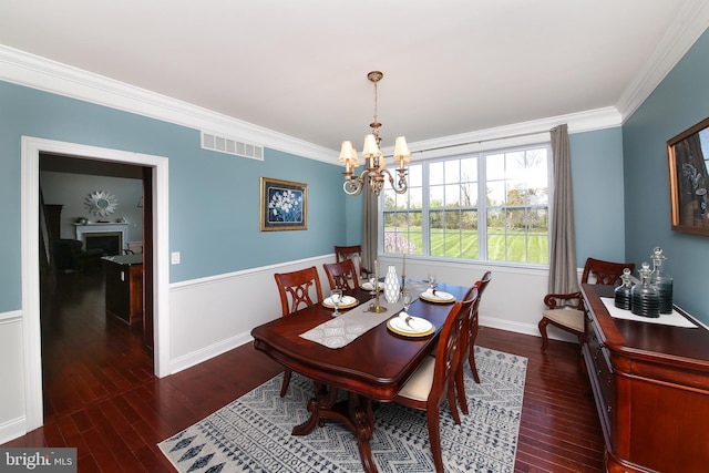 dining room with a notable chandelier, dark hardwood / wood-style floors, and ornamental molding