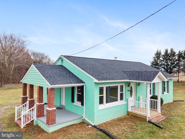 view of front of property featuring covered porch and a front yard