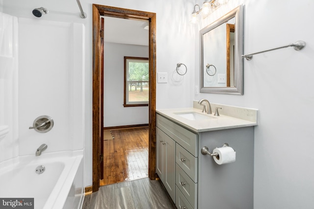 bathroom featuring wood-type flooring, vanity, and tub / shower combination