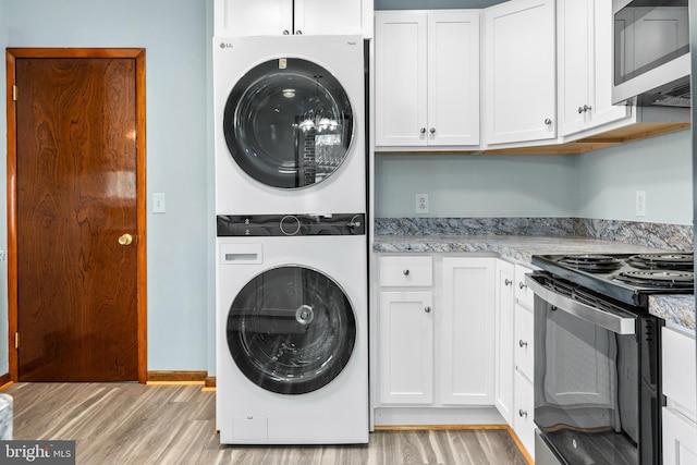 laundry room with light hardwood / wood-style floors and stacked washer and dryer