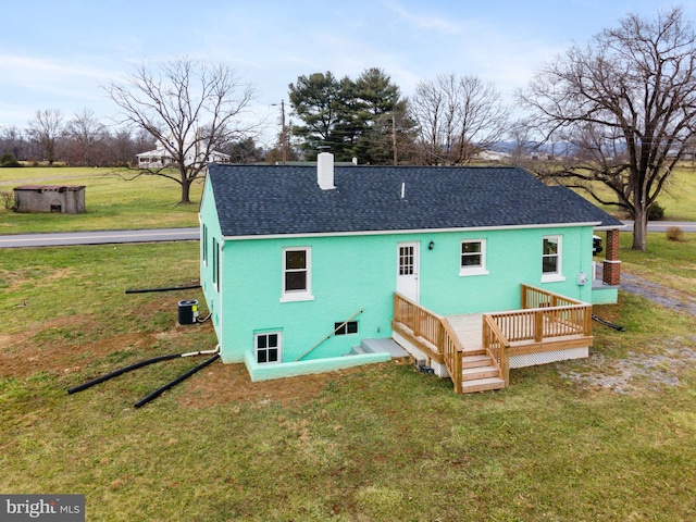 rear view of property with a lawn, cooling unit, and a wooden deck