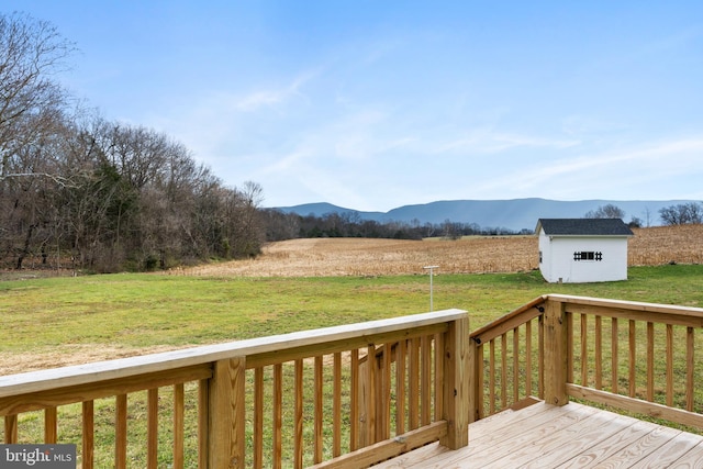 deck with a lawn, a mountain view, a rural view, and a shed