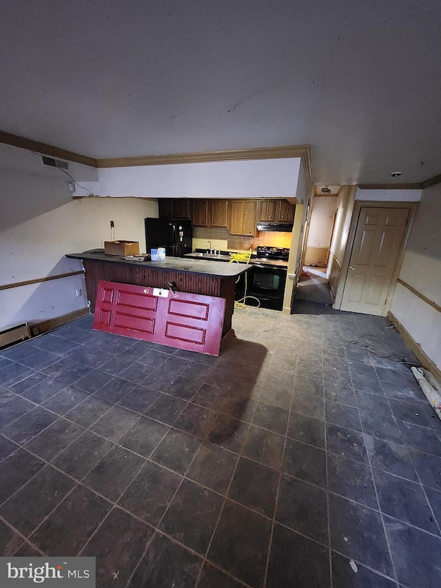 kitchen featuring ornamental molding, black appliances, a center island, and a breakfast bar area