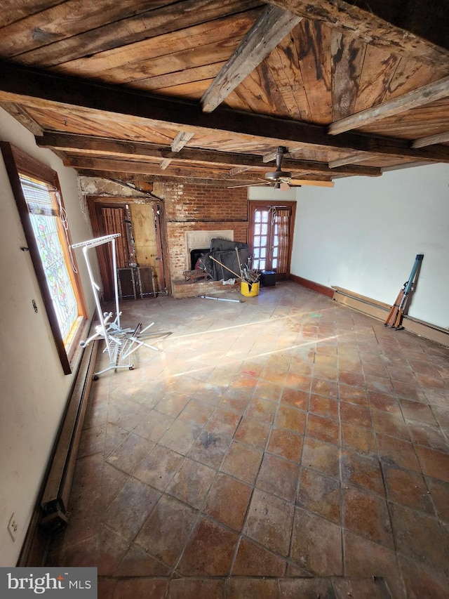 unfurnished living room with wood ceiling, french doors, a brick fireplace, and beam ceiling