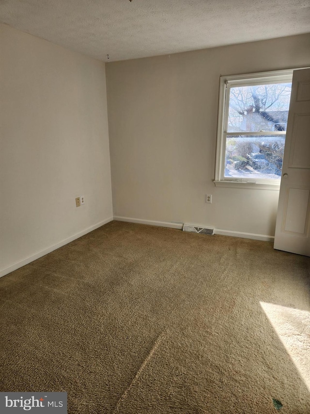 unfurnished room featuring carpet floors and a textured ceiling