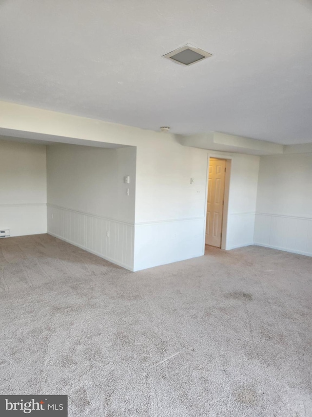 unfurnished room with carpet floors and a baseboard heating unit