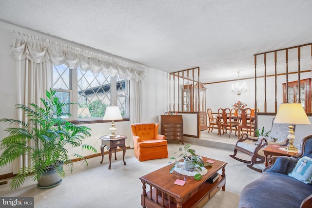 living room featuring carpet flooring, ornamental molding, a textured ceiling, and a notable chandelier