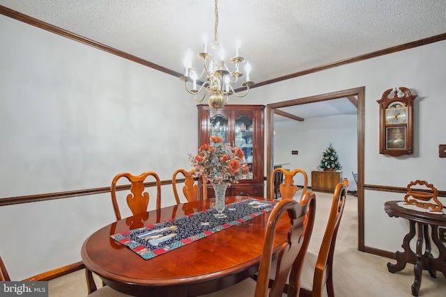 dining room with a notable chandelier, light colored carpet, ornamental molding, and a textured ceiling