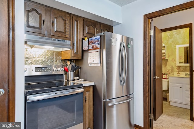 kitchen featuring dark brown cabinets, appliances with stainless steel finishes, and tasteful backsplash