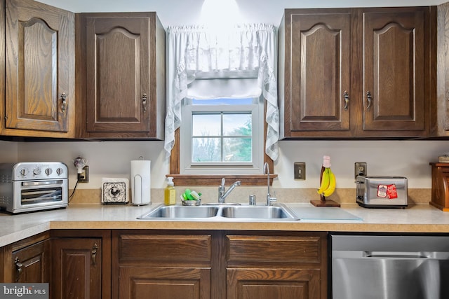 kitchen with dark brown cabinetry, dishwasher, and sink