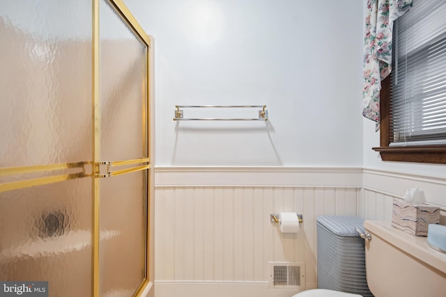 bathroom featuring an enclosed shower and toilet