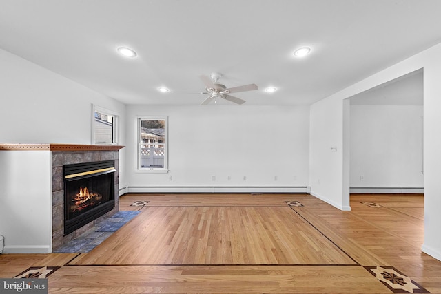 unfurnished living room featuring baseboard heating, a fireplace, and hardwood / wood-style floors