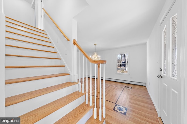 entryway featuring a notable chandelier, light wood-type flooring, and a baseboard radiator