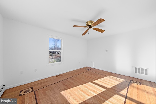 spare room with hardwood / wood-style floors, a baseboard radiator, and ceiling fan