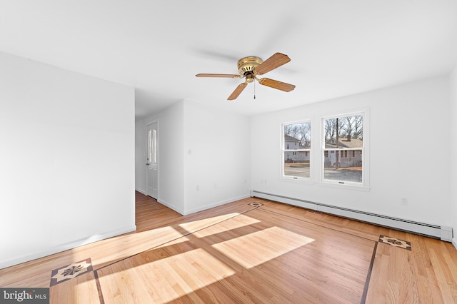 spare room with ceiling fan, light hardwood / wood-style flooring, and a baseboard heating unit