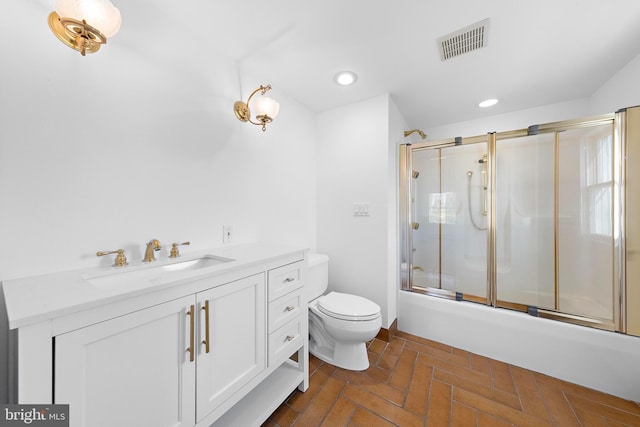 full bathroom with shower / bath combination with glass door, vanity, and toilet