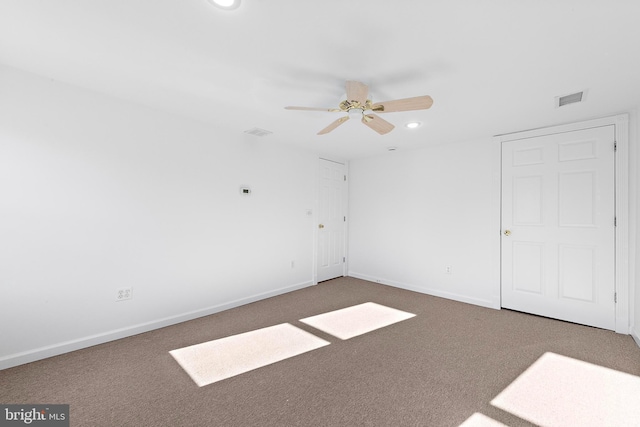 carpeted spare room with ceiling fan