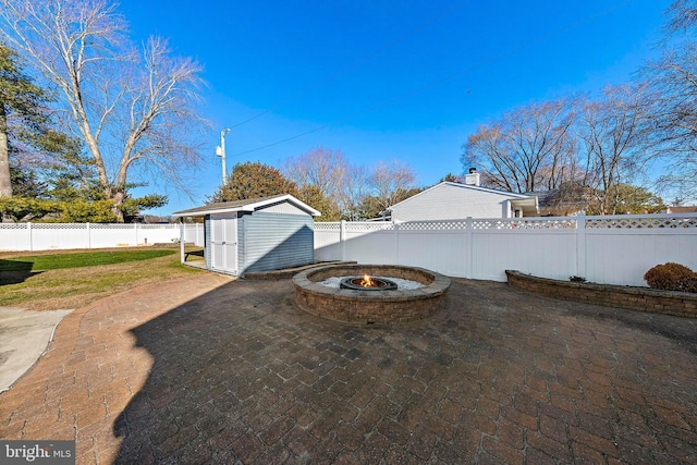 view of patio / terrace featuring a shed and a fire pit